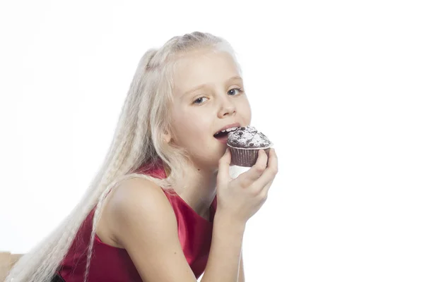 Meisje bijten een chocoladecake — Stockfoto