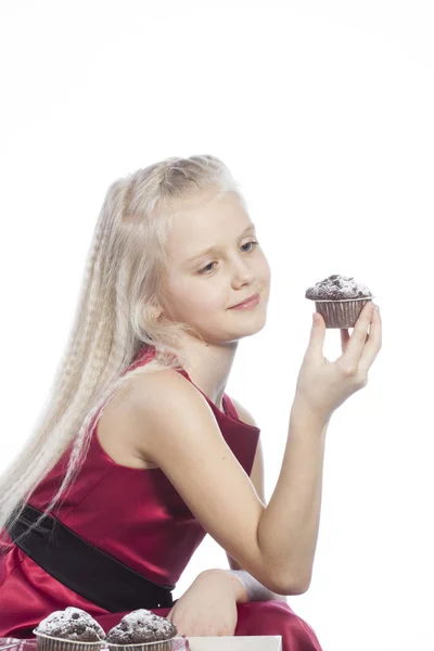 Mädchen beißt in einen Schokoladenkuchen — Stockfoto