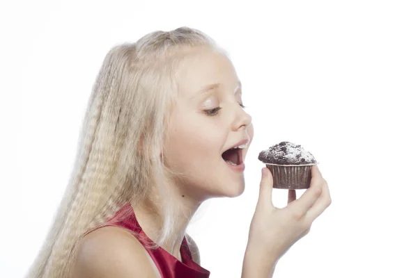 Chica mordiendo un pastel de chocolate — Foto de Stock