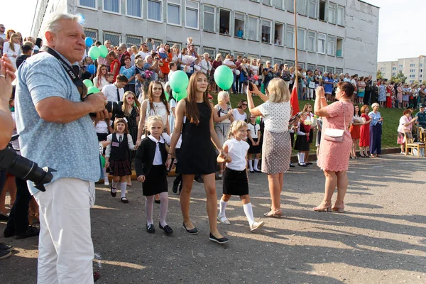 Gli studenti delle scuole superiori accompagnano i primi alunni a un incontro festivo — Foto Stock