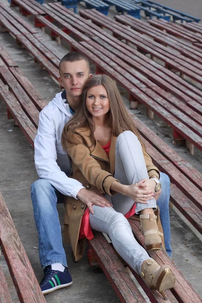 Elegante jovem casal abraçando em um estádio de esportes ao ar livre . — Fotografia de Stock