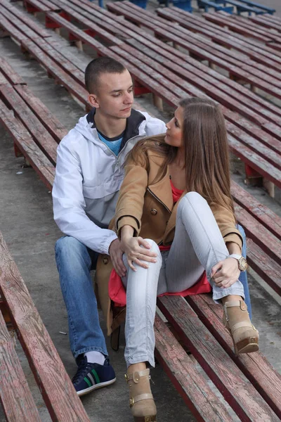 Stijlvol jong koppel knuffelen in een sportstadion buiten. — Stockfoto