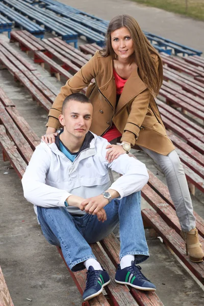 Stijlvol jong koppel knuffelen in een sportstadion buiten. — Stockfoto