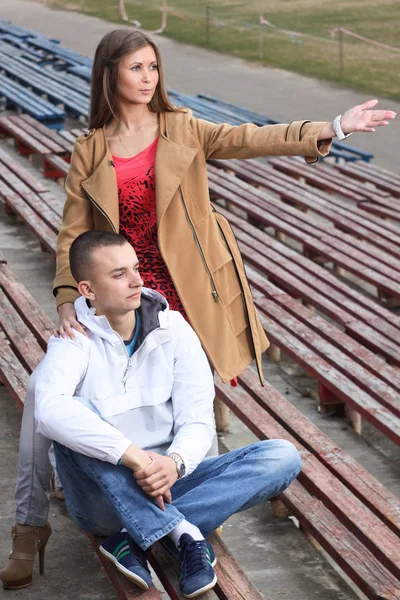 Stylový mladý pár, který se objímat na sportovním stadionu venku. — Stock fotografie