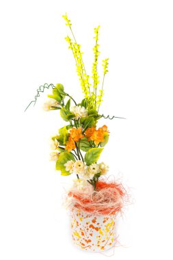 Beyaz arkaplanda izole edilmiş bir tencerede yapay çiçeklerle kompozisyon