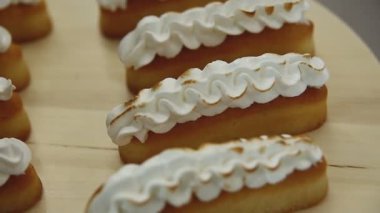 Döndürme masasında kremalı limonlu turtalar. Meringue yakma süreci.