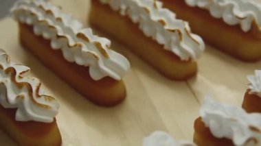 Döndürme masasında kremalı limonlu turtalar. Meringue yakma süreci.