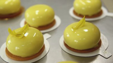 Mutfaktaki pasta şefi pastaları parlatıyor. Aşçı süslemeli pastaları dekoratif bir unsurla dekore eder. Yemek pişirme süreci. Adım adım. Öğretici.