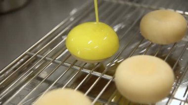 Mutfaktaki pasta şefi pastaları parlatıyor. Pasta şefi dondurulmuş bisküvinin üzerine sıvı krema döküyor. Yemek pişirme süreci. Adım adım. Öğretici.