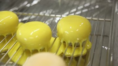 Mutfaktaki pasta şefi pastaları parlatıyor. Pasta şefi dondurulmuş bisküvinin üzerine sıvı krema döküyor. Yemek pişirme süreci. Adım adım. Öğretici.