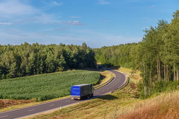 在农村地区 农村地区的一个岔道上 两辆卡车在一个岔道上相互靠拢 卡车在靠近农田和森林的路上行驶 — 图库照片