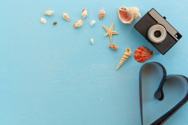 Üst görünüm - Boş kağıt çerçeveler deniz yıldızı, kabuklar ve ahşap masa üzerindeki eşyalar. Yaz turizmi, seyahat ve tatil anıları ve nostalji kavramı. Klasik renk tonu.