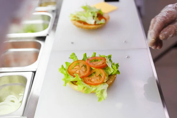 Gotować Dodawanie Sałaty Hamburgera Przygotowuję Hamburgera Restauracji Ręce Kucharza Rękawiczkach — Zdjęcie stockowe