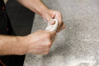 Masa arkasında erkek eli ile para kazanmak. Pizzacı pizza hamuru hazırlıyor..