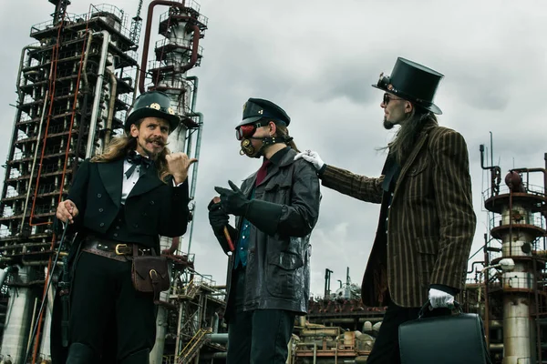 Tři Muži Steampunk Stylu Diskutovat Stojící Průmyslovém Pozadí — Stock fotografie