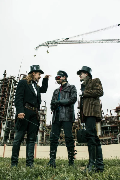 Drie Mannen Steampunk Stijl Bespreken Staan Tegen Industriële Achtergrond — Stockfoto
