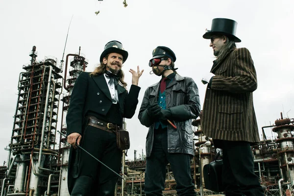 Trei Oameni Stil Steampunk Discută Picioare Fundalul Industrial — Fotografie, imagine de stoc