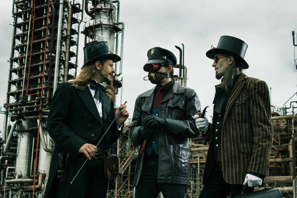 Três Homens Estilo Steampunk Discutir Contra Fundo Industrial — Fotografia de Stock