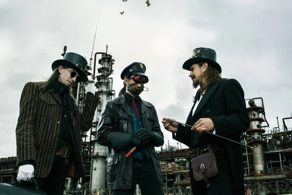 Tres Hombres Estilo Steampunk Discuten Pie Contra Trasfondo Industrial — Foto de Stock