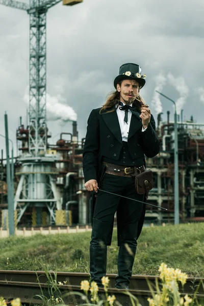 Steampunk Tarzı Giyinmiş Genç Adam Endüstriyel Arka Planda Poz Veriyor — Stok fotoğraf