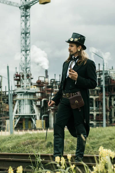 Steampunk Tarzı Giyinmiş Genç Adam Endüstriyel Arka Planda Poz Veriyor — Stok fotoğraf