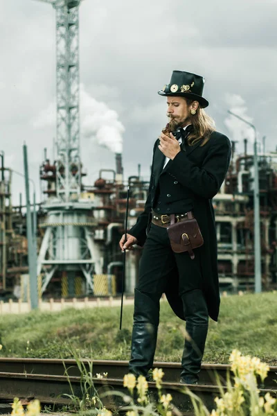 Mladý Muž Nosil Steampunk Stylu Pózování Průmyslovém Pozadí — Stock fotografie