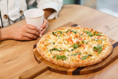 Geleneksel İtalyan pizzasını paylaşan ve bir kafede çay içen arkadaşlarımızın yakın plan görüntüleri.