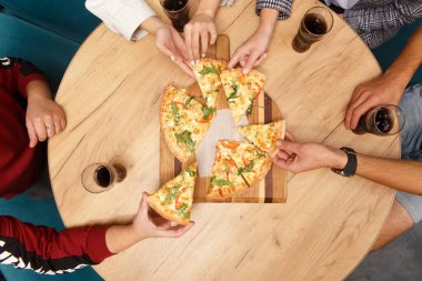 Geleneksel İtalyan pizzasını paylaşan ve bir kafede çay içen arkadaşlarımızın yakın plan görüntüleri.