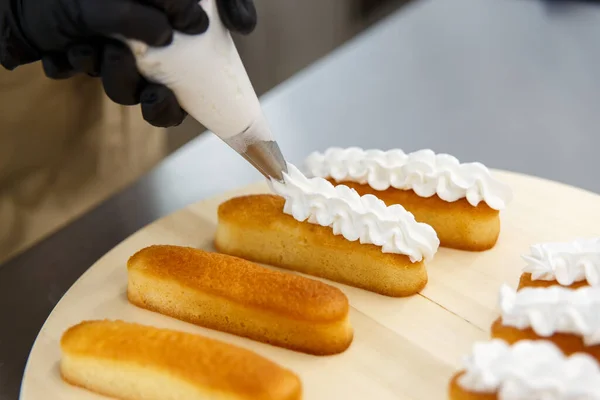과자사는 봉지를 사용하여 케이크 비스켓에 크림을 넣는다 케이크만드는 — 스톡 사진