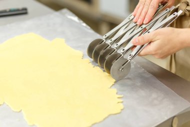 Aşçı özel bir spatula kullanarak kısa ekmeği şeritlere ayırır..