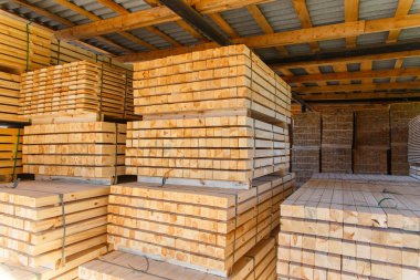 Piles of wooden boards in the sawmill, planking. Warehouse for sawing boards on a sawmill outdoors. Wood timber stack of wooden blanks construction material. Lumber Industry. clipart
