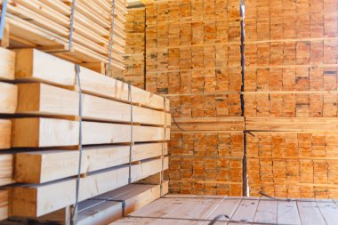 Kereste atölyesinde kereste yığınları. Dışarıdaki bir kereste fabrikasının tahtalarını kesmek için depo. Tahta kereste yığını boş inşaat malzemesi. Kereste Endüstrisi.