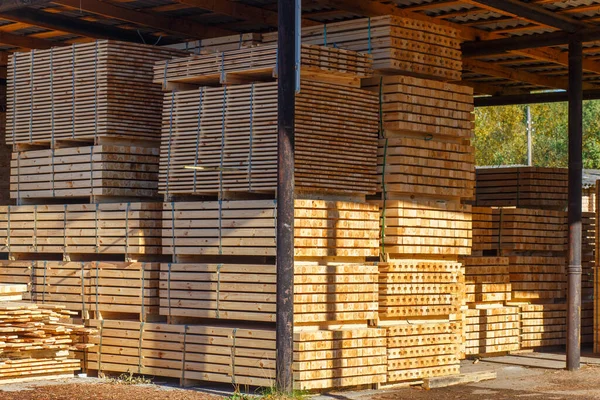 Piles of wooden boards in the sawmill, planking. Warehouse for sawing boards on a sawmill outdoors. Wood timber stack of wooden blanks construction material. Lumber Industry.