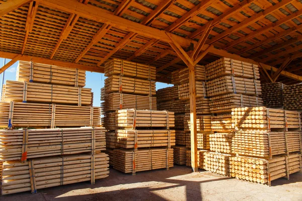 Piles of wooden boards in the sawmill, planking. Warehouse for sawing boards on a sawmill outdoors. Wood timber stack of wooden blanks construction material. Lumber Industry.