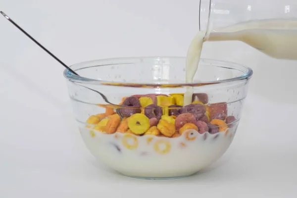 Багатокольорова чаша зернових з заливкою молока на білому тлі — стокове фото