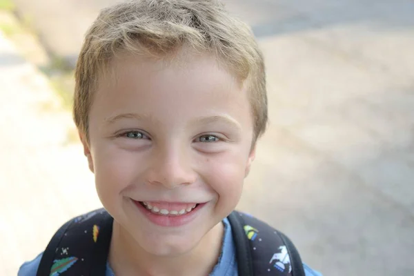 彼のバックパックで学校に行く青い目を持つ笑顔のブロンドの子供 — ストック写真