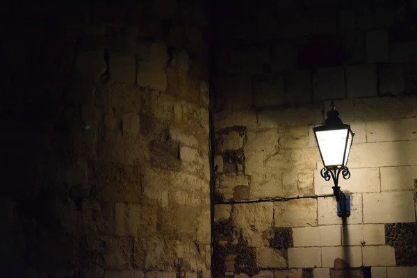 light on a light brown stone wall at night