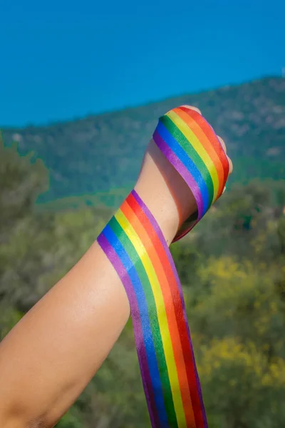 Pugno Caucasico Mano Tenendo Nastro Arcobaleno All Aperto Con Cielo — Foto Stock