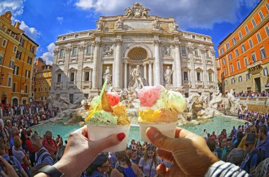 Rome, İtalya - 30 Eylül 2017. Roma, İtalya çevresinde çok sayıda turistin ünlü Trevi Çeşmesi, arka taraftan düzenlenen farklı tatlar ile İtalyan güzel parlak tatlı dondurma külahı ile çift