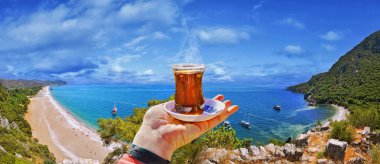 Morning cup of tea with view of colorful panoramic Olympos beach , Cirali clipart