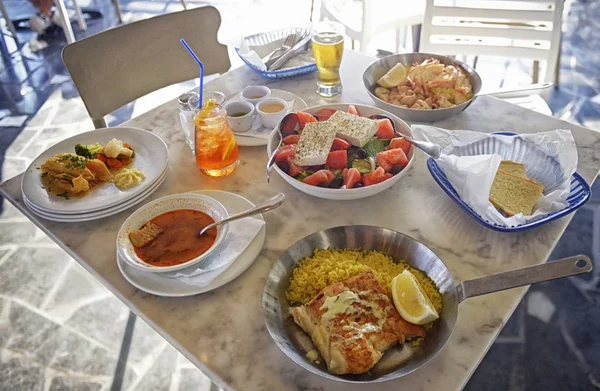 Неизвестные люди едят традиционные вкусные блюда средиземноморской кухни открытый ресторан на Кипре, Айя-Напа Лицензионные Стоковые Фото