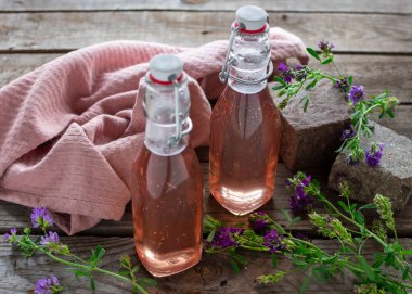Fresh lavender syrup in decorative preserving bottles filled on wood clipart