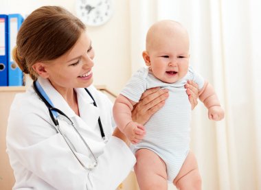 Ağlayan Bebek hastanede. Küçük çocuk genel sağlık kontrolü sırasında holding nazik kadın doktor.
