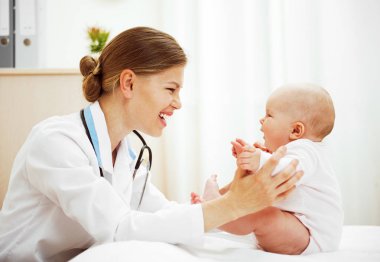 Mutlu gülümseyen bebek klinikteki doktor doktoru ziyaret ediyor..