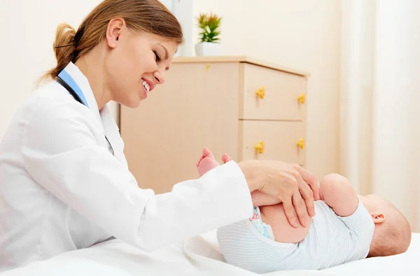 Mulher Ortopedista Massageando Pernas Bebê Sofá — Fotografia de Stock