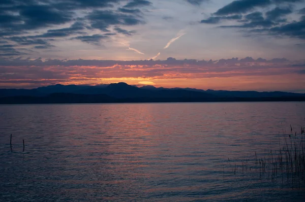 湖の日の出 早朝の風景です シルエットと昇る太陽の光線の山 イタリアのガルダ湖の日の出 — ストック写真
