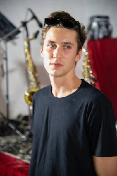 Young Handsome Tall Guy Posing Black Shirt Musical Instruments Background — Stock Photo, Image