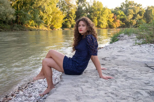 Bir Nehir Kıyısında Oturan Uzun Dalgalı Kahverengi Saçlı Seksi Kızı — Stok fotoğraf