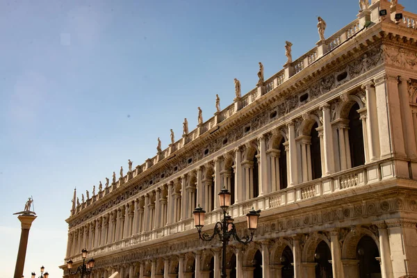 Detail of the Doge\'s Palace, Venice, Italy. Detail of the Doge\'s Palace, the statue of Saint Theodore and the Venetian lamp-posts