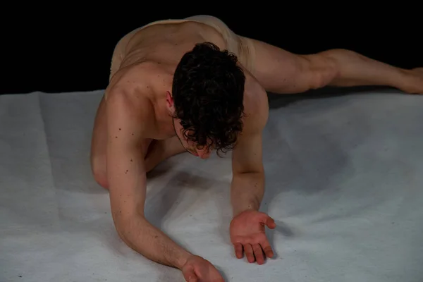 Young male dancer in dance movements. Figures with the body that express in gestures as an expression of the soul. The young man in conceptual demonstrations of modern dance.